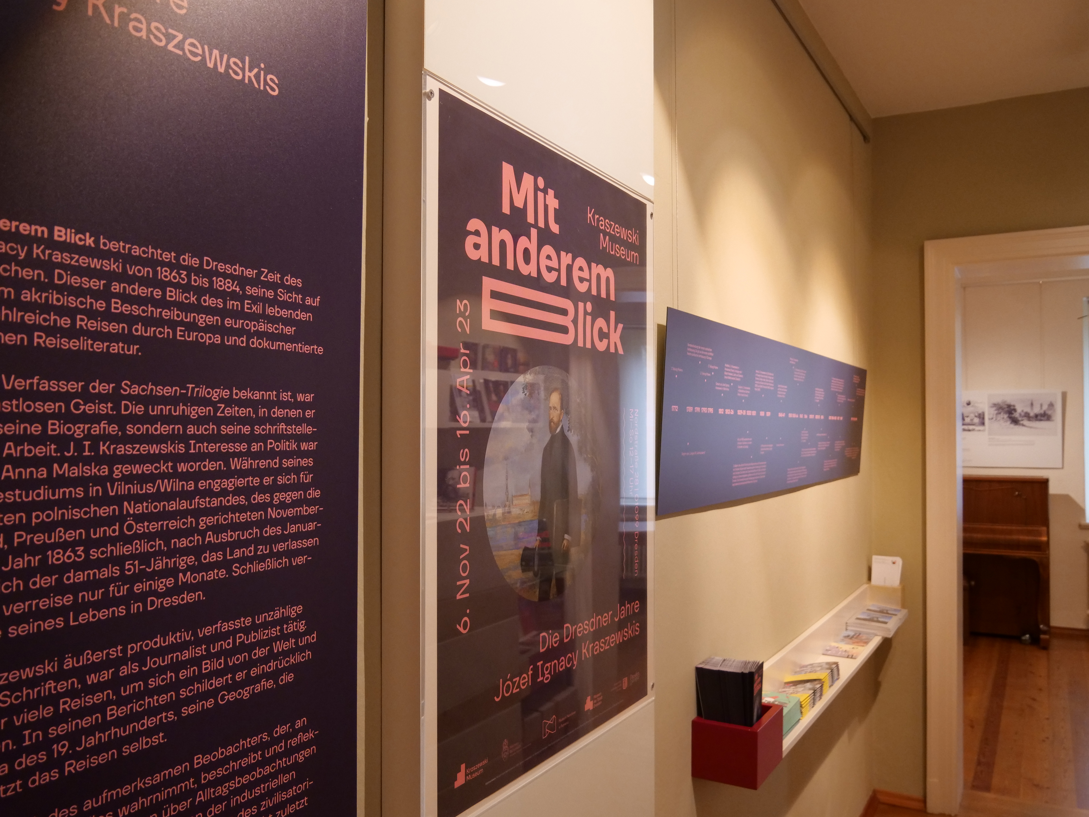 KI generiert: Das Bild zeigt eine Ausstellung im Kraszewski-Museum mit dem Titel "Mit anderem Blick," die sich auf die Dresdner Jahre des Schriftstellers Józef Ignacy Kraszewski konzentriert. An einer Wand sind verschiedene Informationstafeln zu sehen.